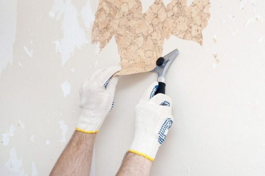 Loại bỏ lớp sơn bong tróc cũ để sơn chống thấm mới cho tường nhà