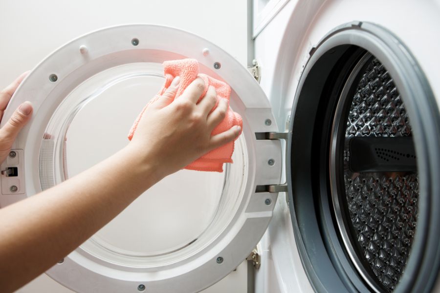 Sử dụng khăn mềm để vệ sinh cửa máy giặt