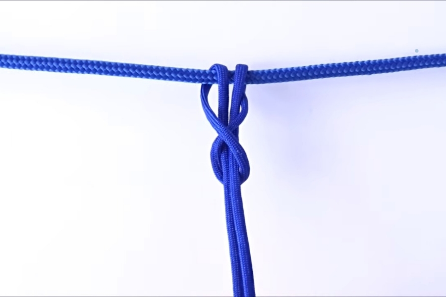Luồn ngón giữa tay trái vào giữa sợi dây và kéo xuống.