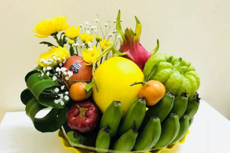 Mẫu mâm ngũ quả Trung Thu hài hòa giữa màu xanh, đỏ, cam của các loại trái cây kết hợp với màu vàng nổi bật của hoa cúc.