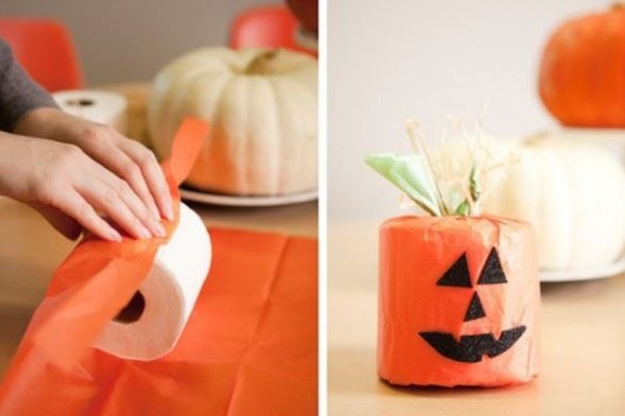 Tạo hình quả bí ngô Halloween bằng cách kết hợp giữa cuộn giấy vệ sinh và túi rác màu cam.