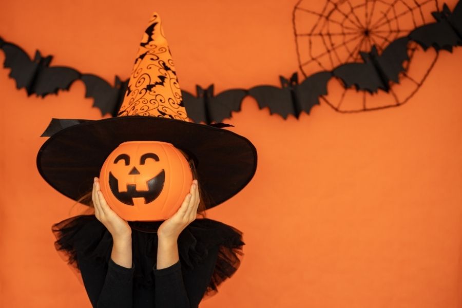 Hóa trang Halloween với mặt nạ bí ngô và mũ phù thủy.