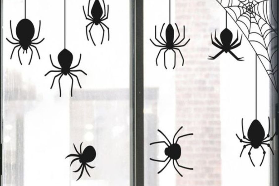 Trang trí cửa sổ Halloween với hình dán nhện.