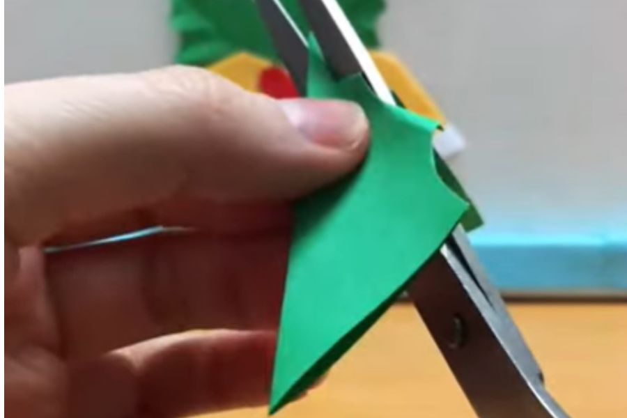 Dùng mảnh giấy màu xanh để làm hoạ tiết lá, tạo điểm nhấn cho chiếc chuông Noel.