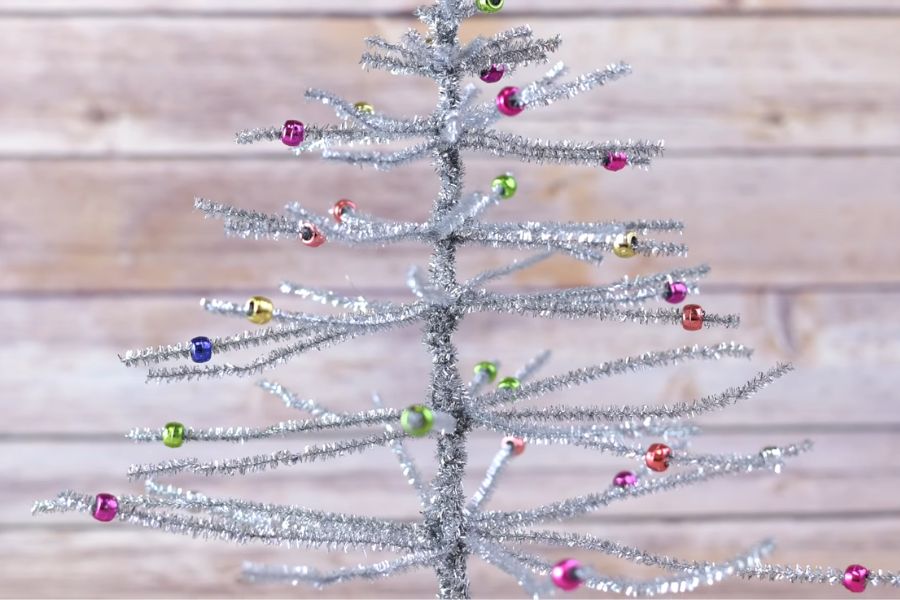Làm cây thông Noel bằng kim tuyến màu bạc tựa tuyết phủ.