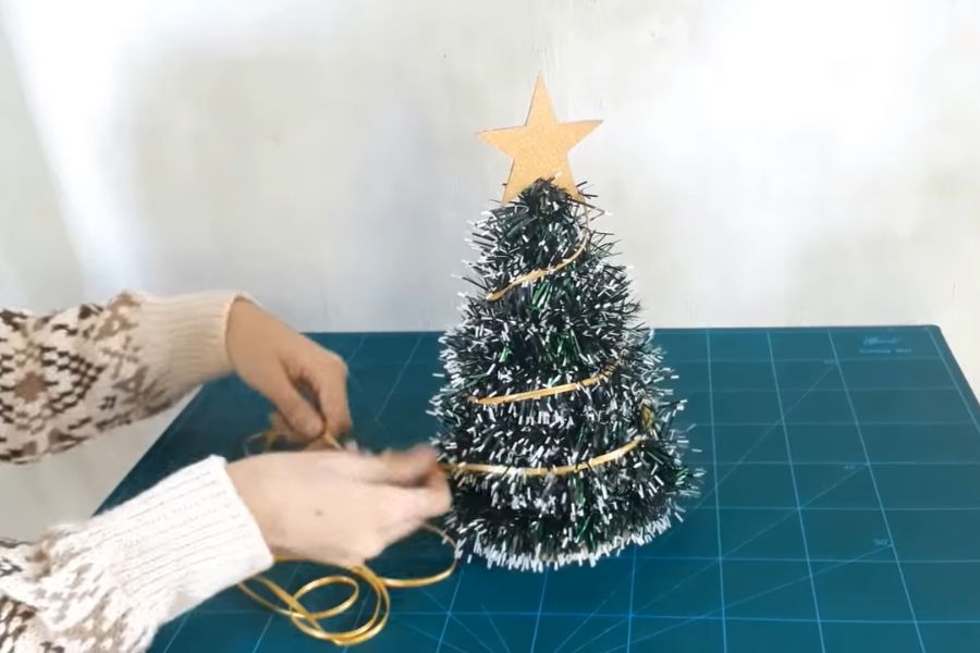 Gắn phụ kiện để trang trí cây thông Giáng Sinh.