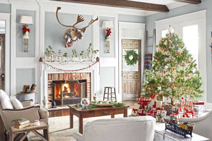 Mẫu trang trí Noel tại nhà dành cho khu vực phòng khách với cây thông Noel cùng đầu chú nai được đặt nổi bật phía trên lò sưởi.
