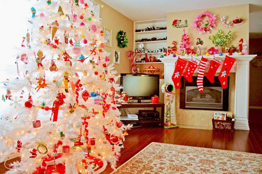 Mẫu trang trí phòng khách Noel với cây thông trắng cùng các món phụ kiện tông đỏ chủ đạo.