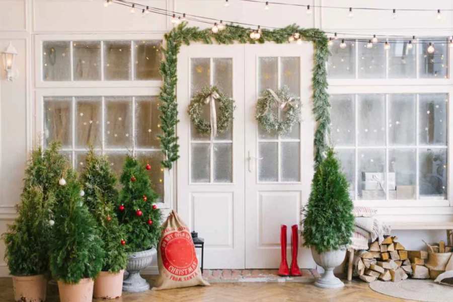 Mẫu trang trí Noel tại nhà dành cho lỗi đi và cửa ra vào đơn giản với những chậu thông mini, vòng nguyệt quế và đèn led lấp lánh.
