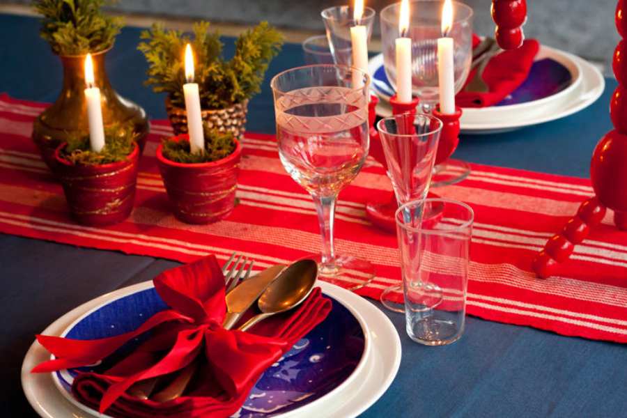 Trang trí bàn tiệc Noel với nến và hoa đỏ nhận được sự quan tâm và yêu thích.