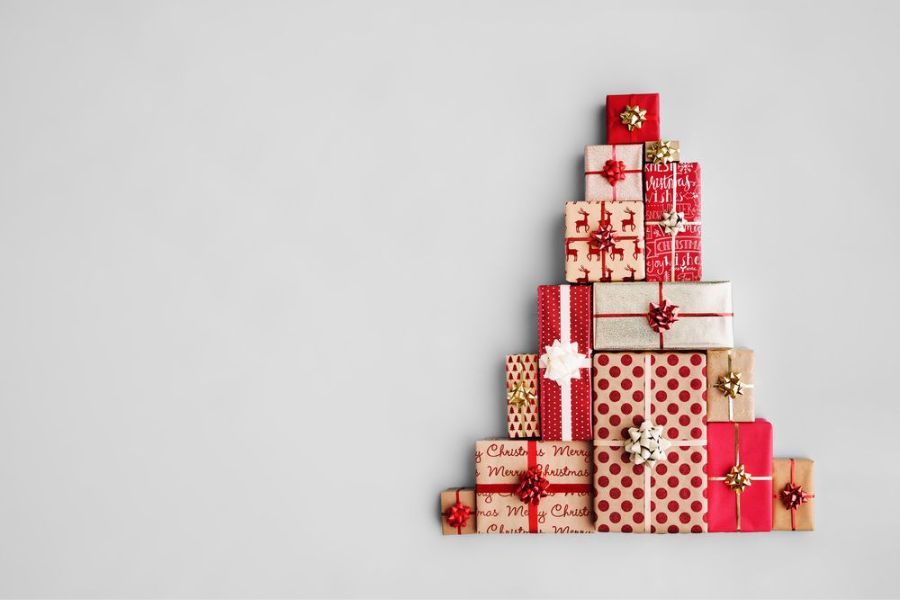 Trang trí cây thông Noel bằng cách xếp những hộp quà tặng.