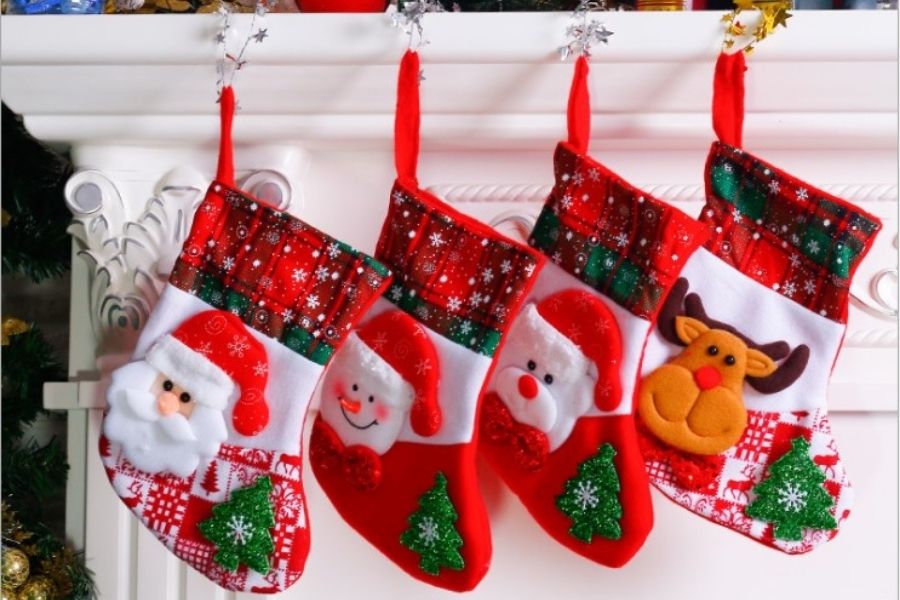 Cô giáo trang trí thêm những chiếc tất Giáng Sinh truyền thống trên lò sưởi.