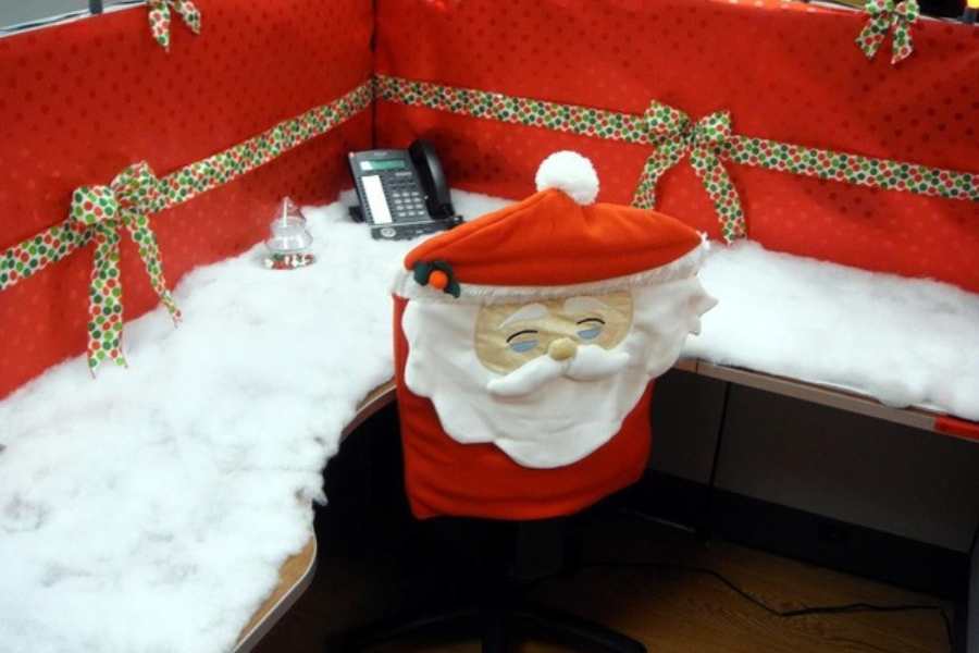 Ý tưởng trang trí bàn làm việc với giấy dán màu đỏ cùng ruy băng và vỏ bọc ghế hình ông Noel đầy sáng tạo.
