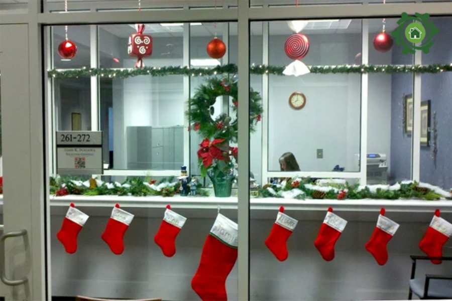 Mẫu trang trí Noel cho văn phòng với những chiếc tất đỏ nổi bật được treo trước cửa ra vào.