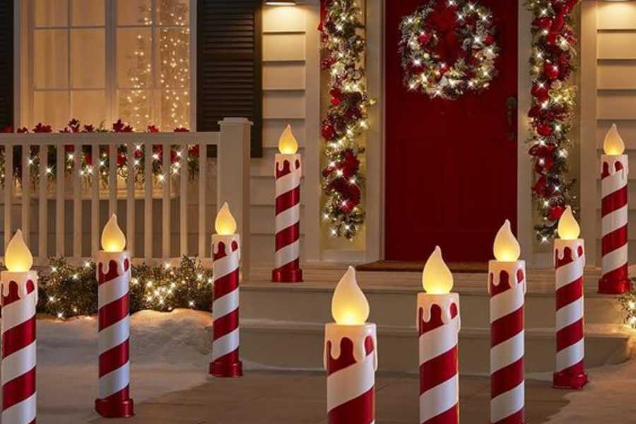 Ý tưởng trang trí Giáng Sinh ngoài trời với điểm nhấn là những ngọn nến khổng lồ dọc hai bên lối đi.