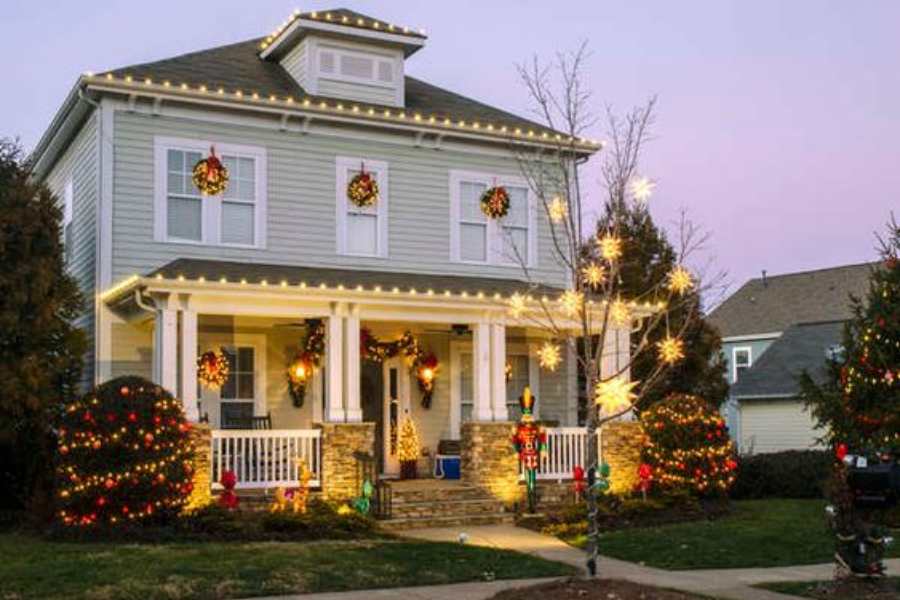 Mẫu trang trí khu vực ngoài trời với các dây đèn lấp lánh cùng với những chiếc vòng nguyệt quế đậm chất Giáng Sinh.