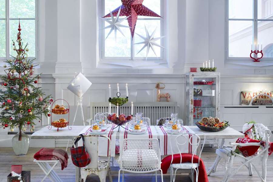 Khu vực ăn uống được trang trí Noel theo phong cách đơn giản với cây thông, ngôi sao và thảm bàn màu đỏ.