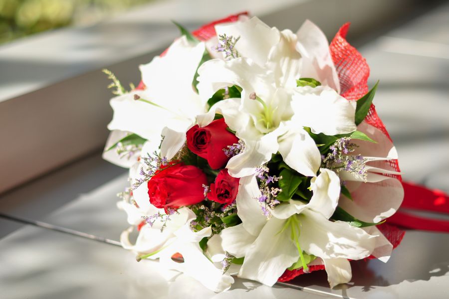 Hình ảnh bó hoa cưới được làm từ hoa ly trắng và hoa hồng đỏ.