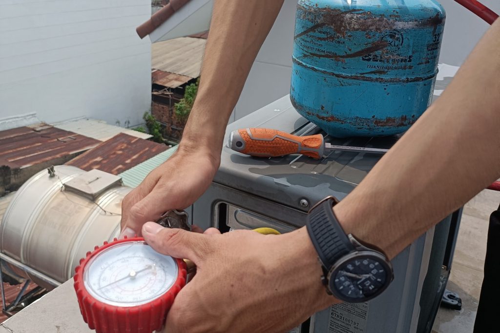 Tasker vệ sinh máy lạnh của bTaskee đang tiến hành bơm gas máy lạnh.