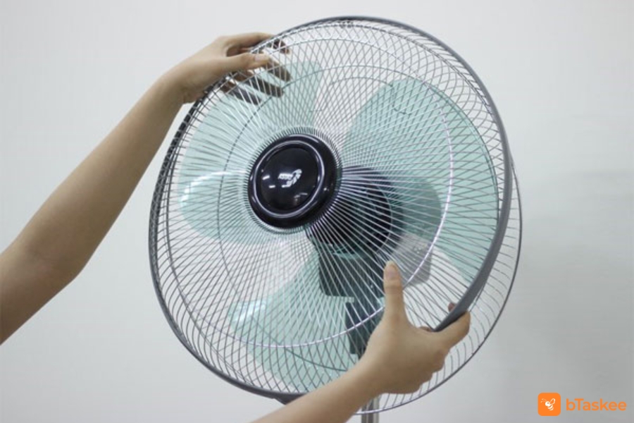 Tháo lồng trước máy quạt.