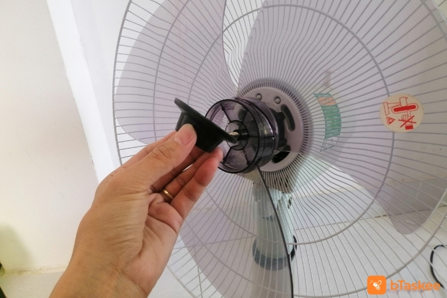 Xoay núm vặn ở giữa trục máy quạt.